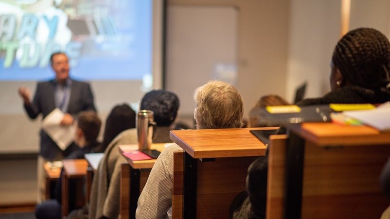 Amphithéâtre universitaire avec des étudiants et un professeur au premier plan