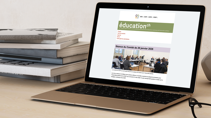 Un ordinateur portable est posé sur la table, l'écran affiche l'infolettre de la CDIP.