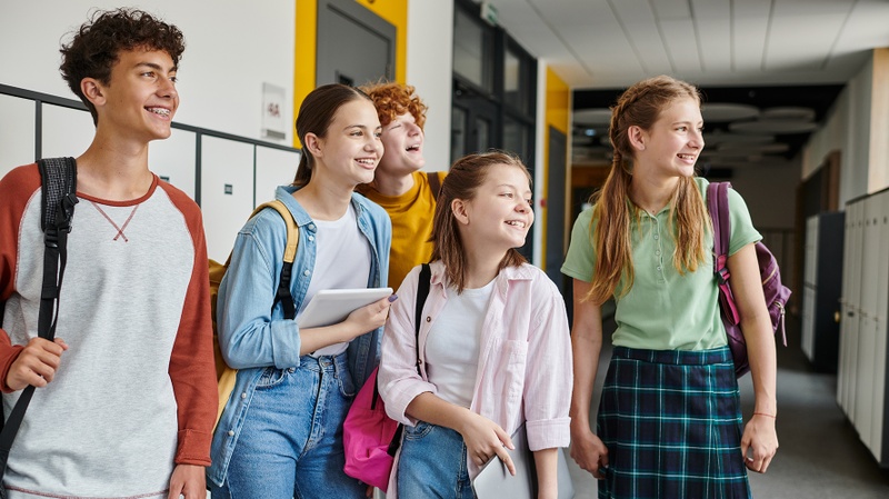 Photo de quatre adolescents à l'école, regardant tous dans la même direction