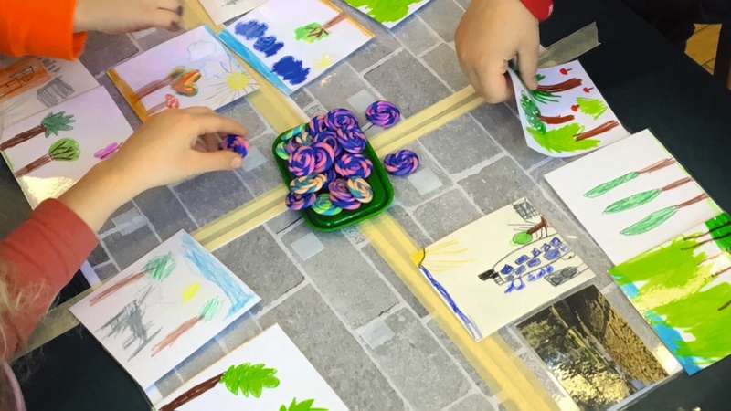 Kinderzeichnungen und Kinderhände, die mit Knete spielen